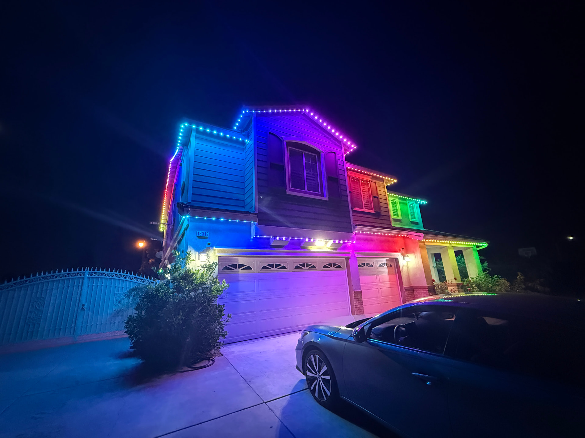 Multicolor permanent lighting across a residential roofline