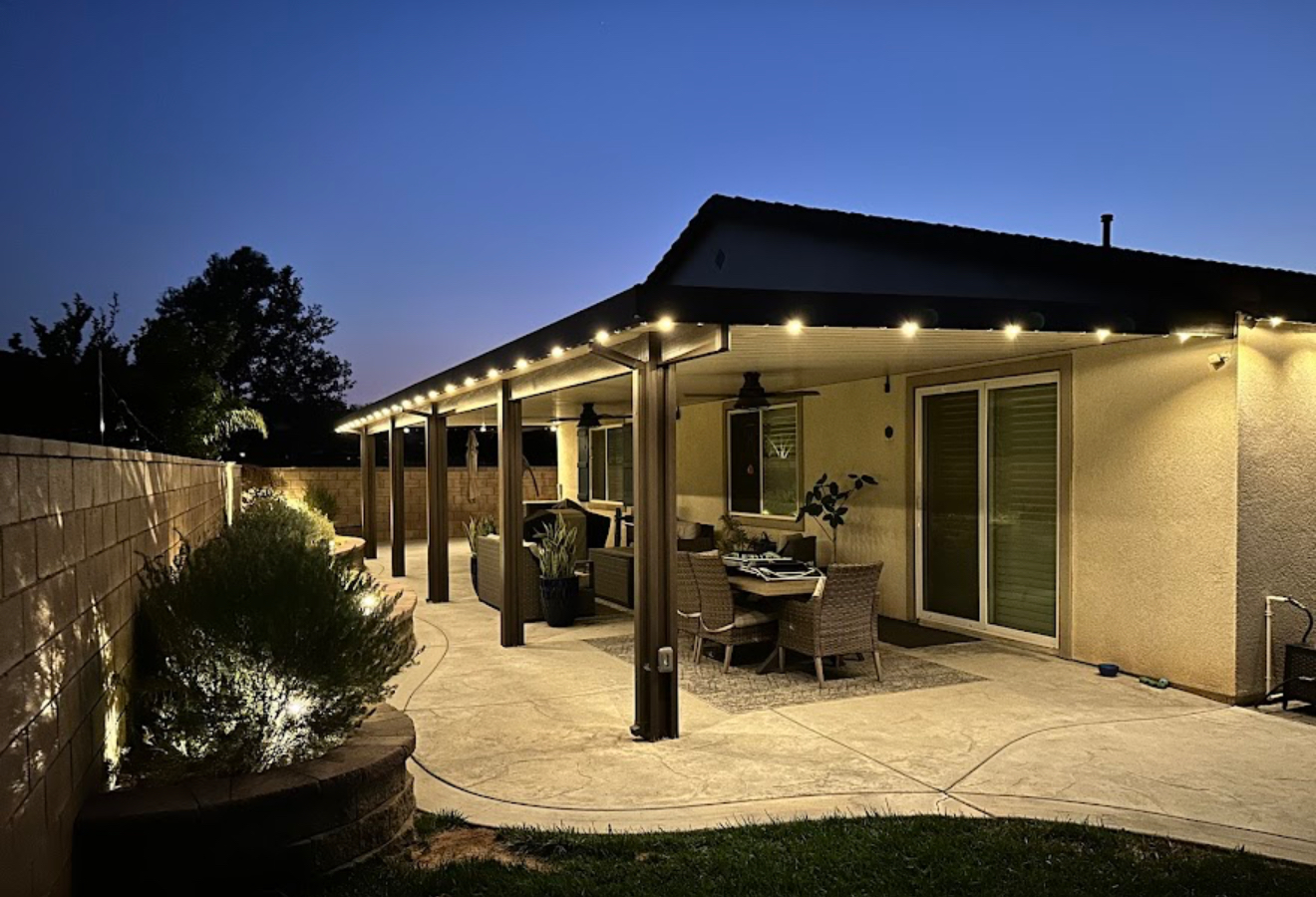 Permanent lighting around a covered patio at dusk